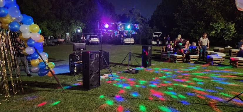 Pista de baile en el pasto de una quinta, de noche, con luces de colores